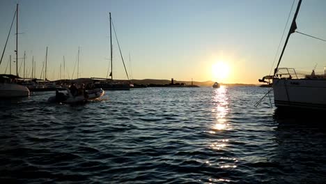 boats and yachts enter and exit marina at sunset in biograd in croatia