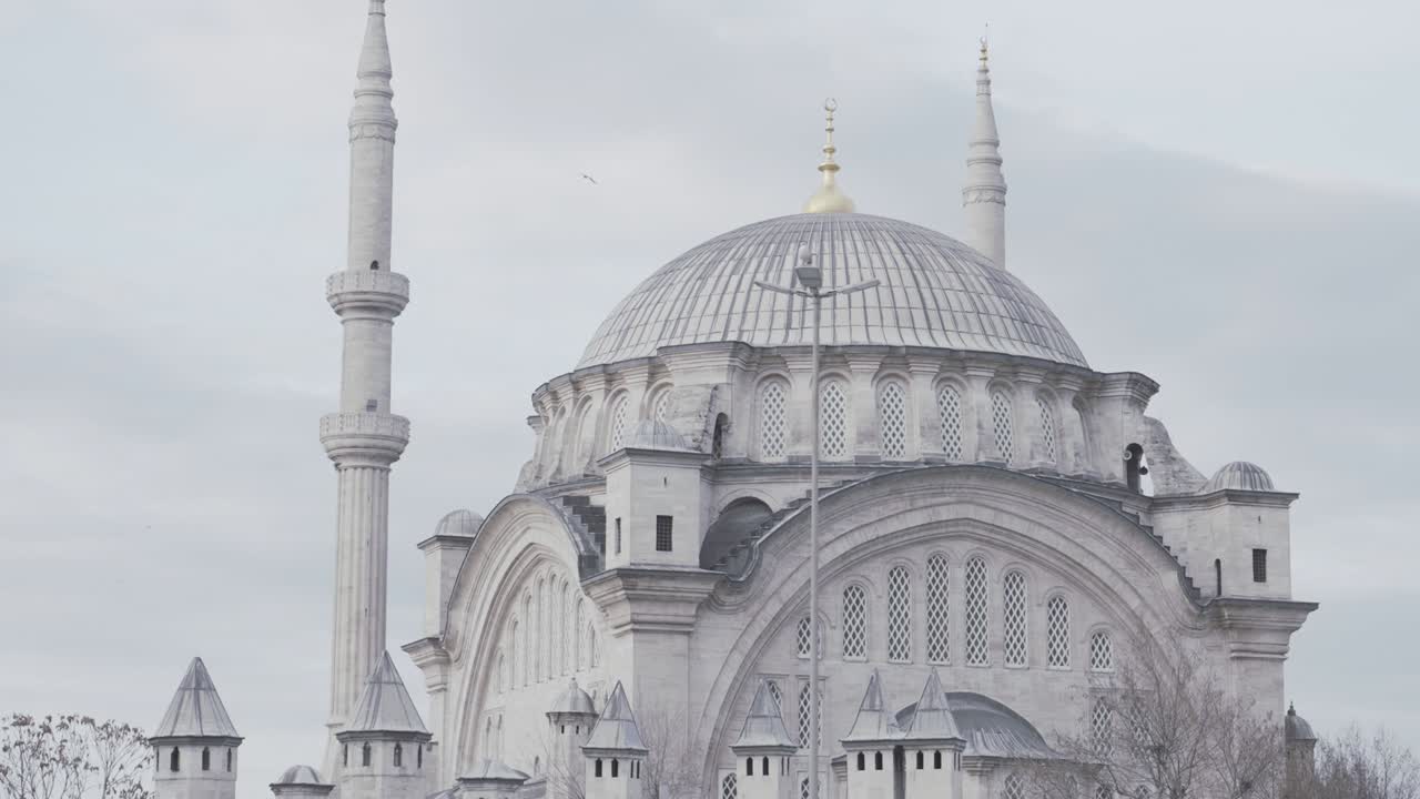 Breathtaking grand mosque in a morning haze. Action. Big white muslim mosque on cloudy sky background, amazing oriental architecture.