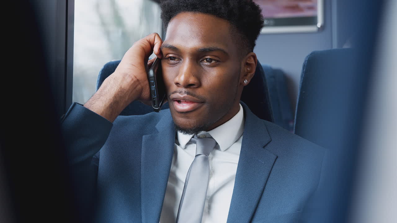 기차에 앉아 휴대전화로 이야기하는 사업가