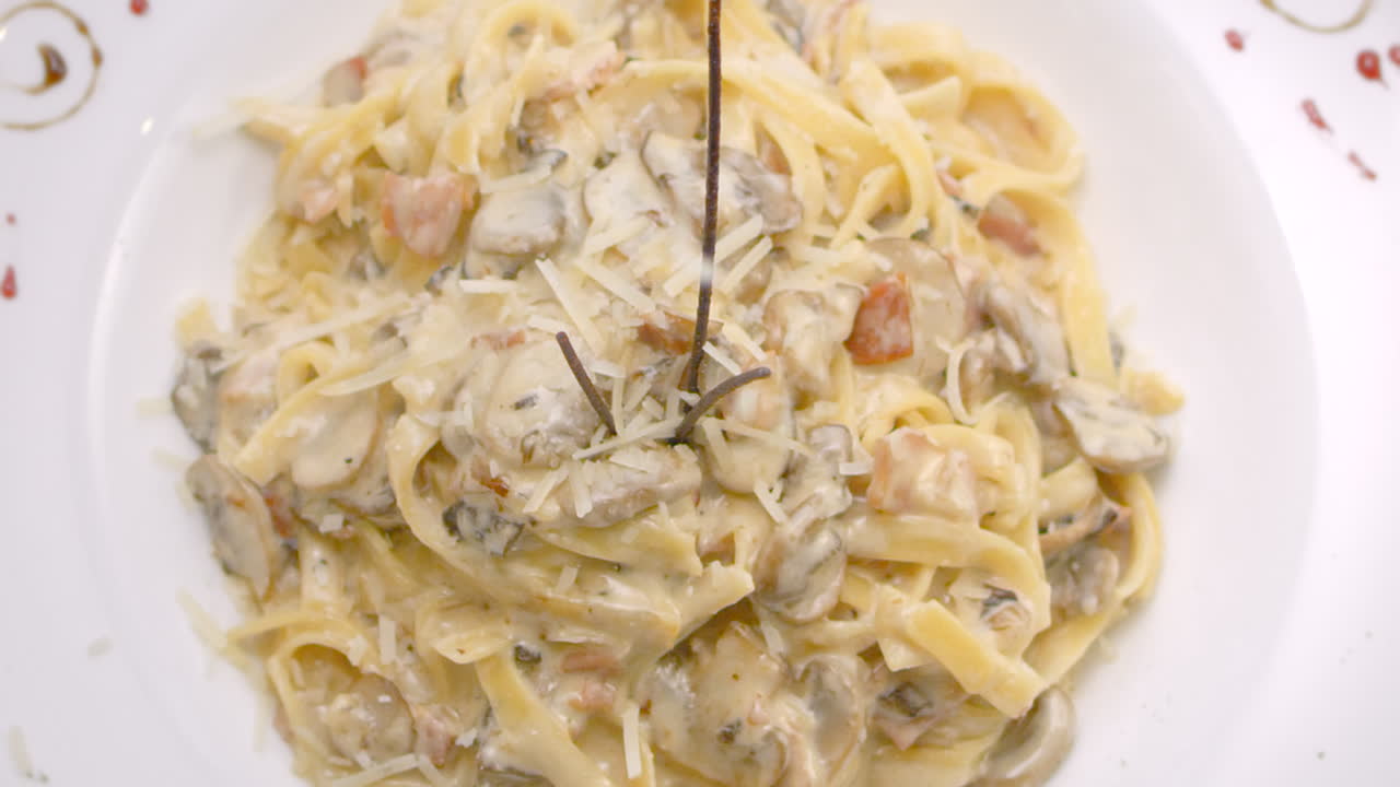 espaguetis en salsa de champiñones con queso rallado, primer plano, mediterráneo