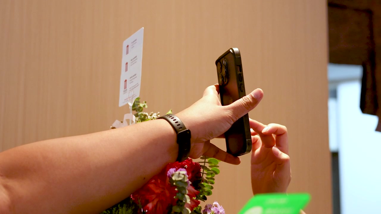 Close-up shot of a hand using a smartphone to scan a QR code for payment
