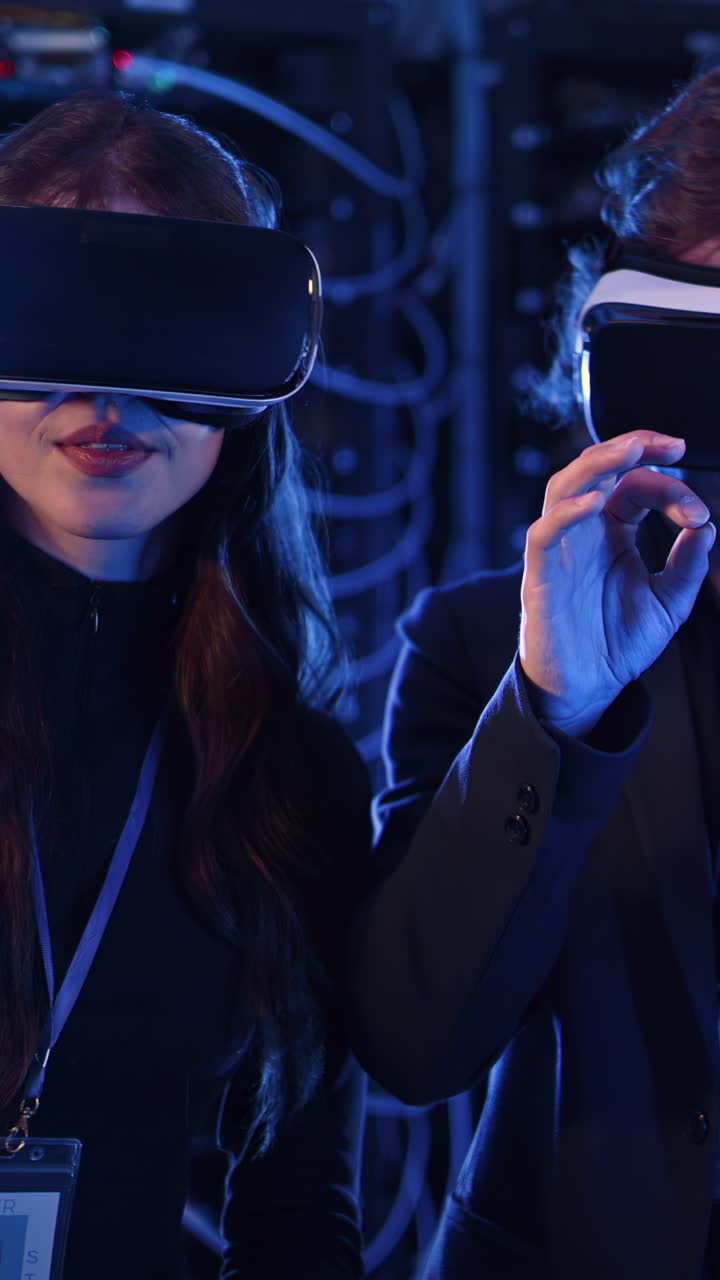 A man and a woman using Virtual Reality headsets in a server room. Vertical