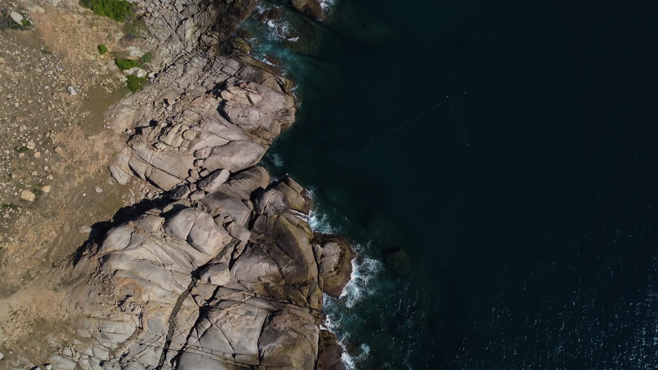 Onde oceaniche che colpiscono la costa rocciosa del Vietnam, vista aerea dall'alto