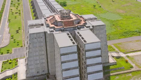 faro a colon museum structure surrounded by green grass fields in santo domingo - aerial orbit shot