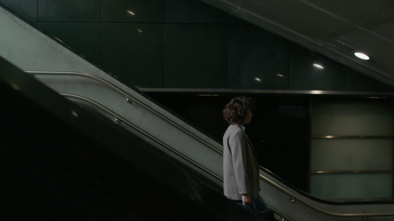 Mulher Subindo Escada Rolante em uma Estação de Metrô Moderna