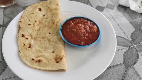 a simple yet flavorful dish featuring soft chapati served with rich sambal sauce. this indian flatbread, made from wheat flour, pairs perfectly with the spicy, tangy condiment.