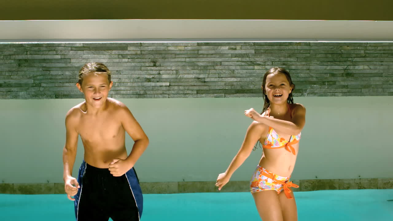 hermanos bailando y sumergiéndose en la piscina