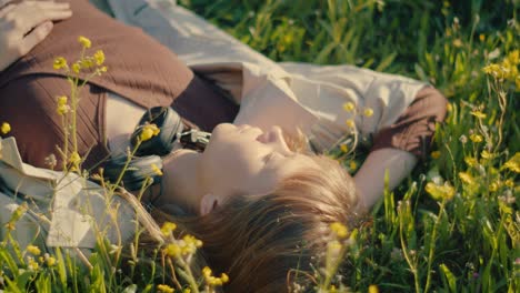 carefree young woman with headphones around neck lying in meadow basking in sun