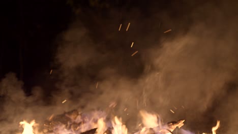 tiro de fuego abierto ardiendo con llamas subiendo en la fría noche de invierno en el país de las maravillas de invierno del mercado de navidad