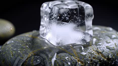 a close-up view of a crystal clear ice cube resting on a textured stone surface, surrounded by water droplets and captivating details of nature