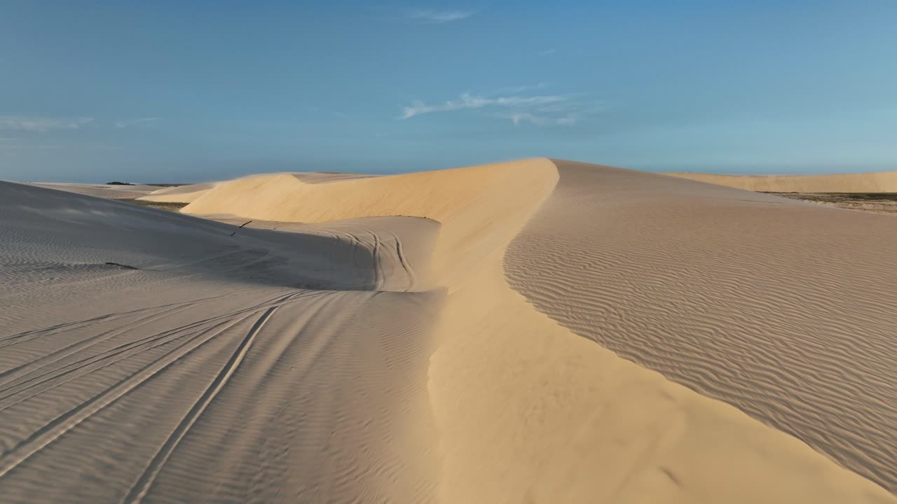 Top-down view of vast white sand dunes with scattered lagoons at Lençóis Maranhenses National Park