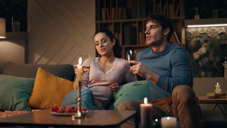 romantic couple clinking glasses celebrating anniversary at home late evening.