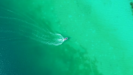 drone aerial landscape of jet ski water activities speed boat across lagoon lake sandbar beach inlet in bacalar village town mexico travel sports vacation tourism