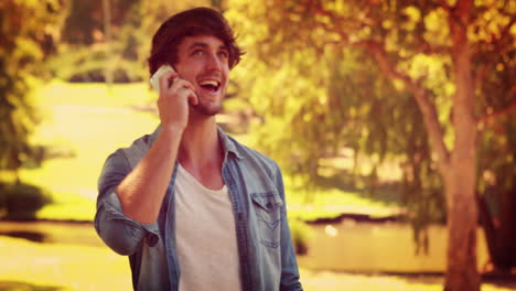 handsome man having a phone call in the park