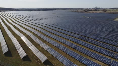 Vast-solar-panel-field-beside-a-lake-on-a-sunny-day,-landscape-view