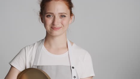 redheaded waitress in front of camera on gray background.