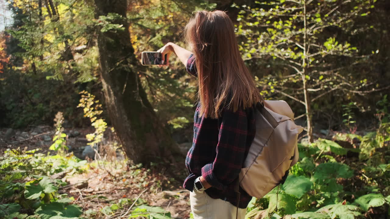Woman Taking a Photo in a Forest