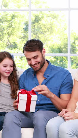 cute girl giving present to father