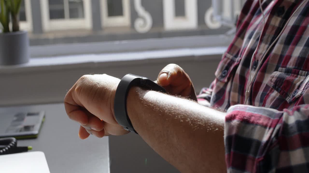 alto ejecutivo masculino usando smartwatch en la oficina 4k