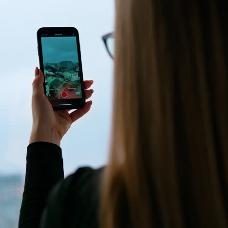 a beautiful smiling woman wearing eyeglasses is using a phone