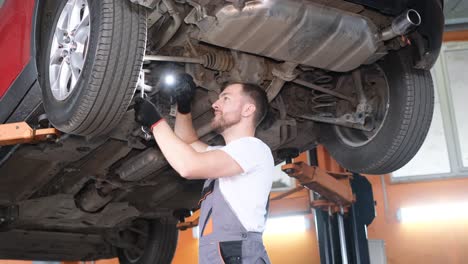 mechanic inspecting the undercarriage of a car on a lift