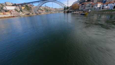 speeding by boats in europe over river fpv drone dom luis bridge porto portugal