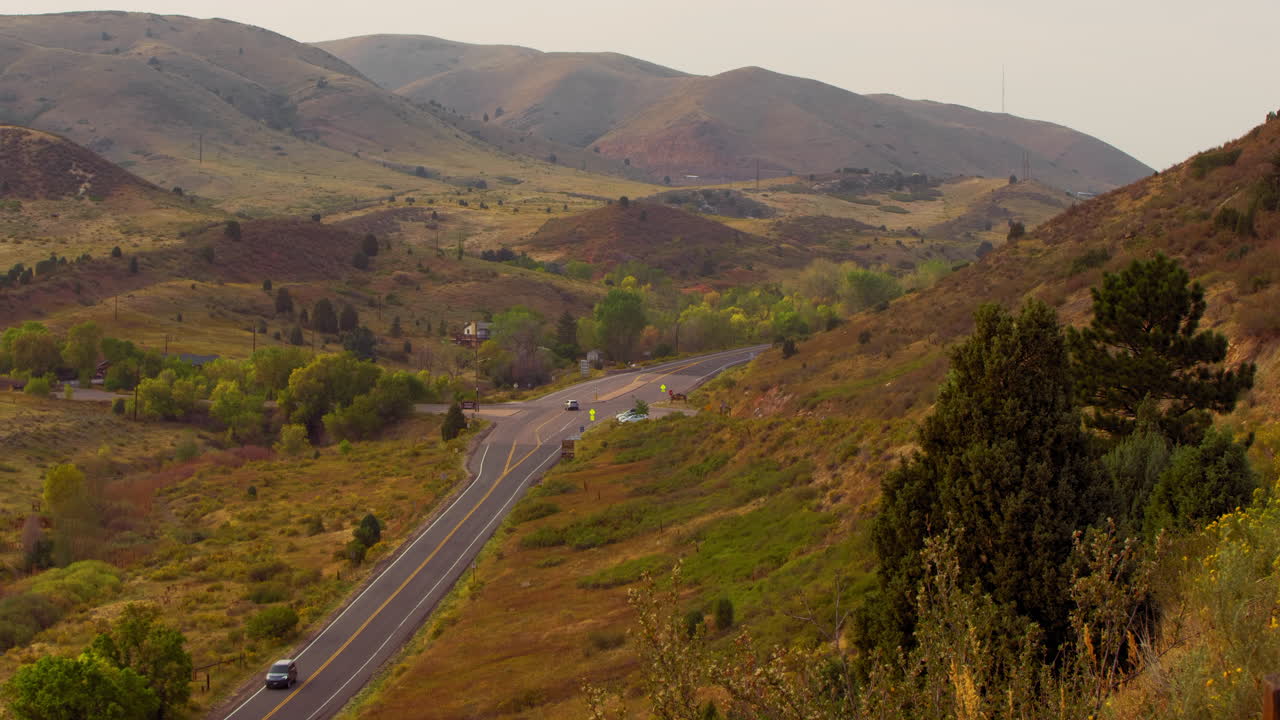 coches circulando por una carretera fuera de rocas rojas en colorado