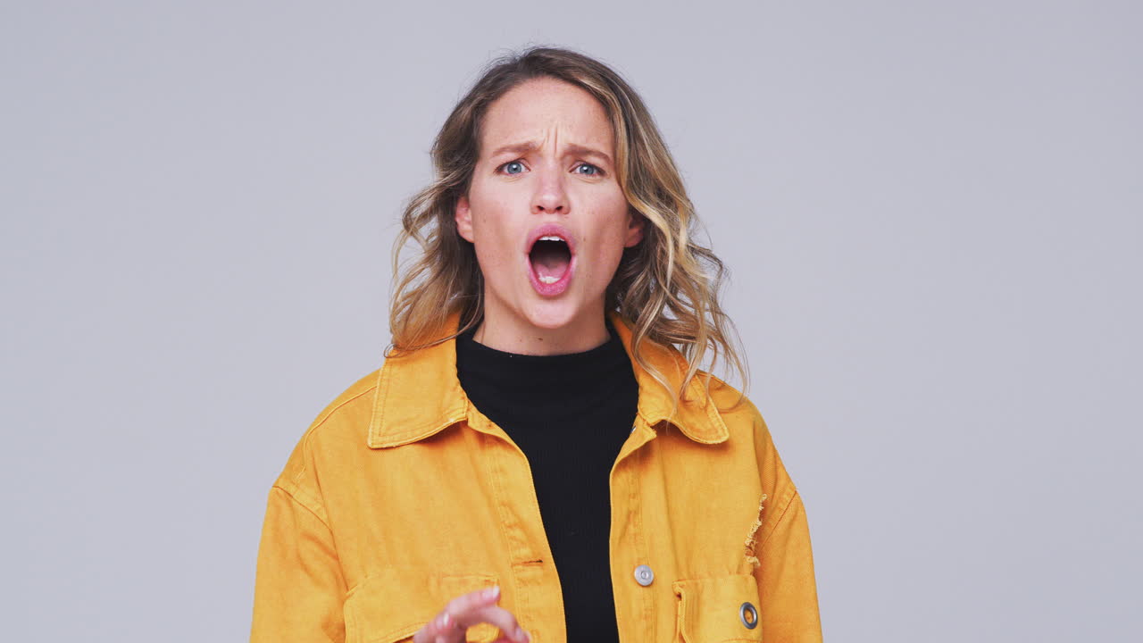 toma de estudio de gran ángulo de una mujer enojada gritando a la cámara en cámara lenta