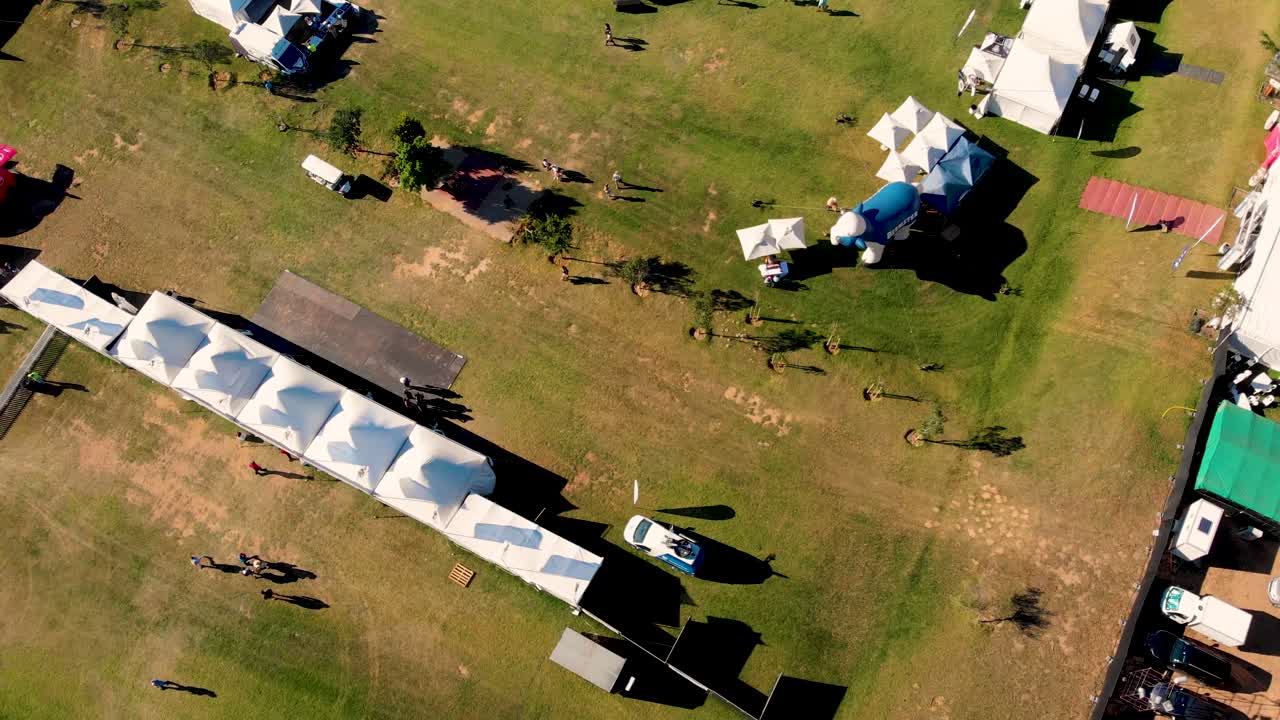 este metraje de avión no tripulado proporciona una vista aérea de un evento vibrante que recuerda a un concierto, donde la gente está bulliciosa
