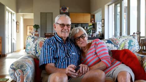 pareja de ancianos viendo la televisión en el sofá 4k