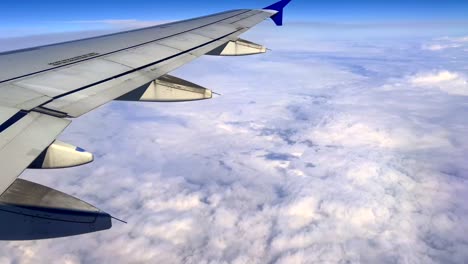 Tilt-up-of-jet-Airbus-A320-airplane-wing-flying-high-in-blue-sky