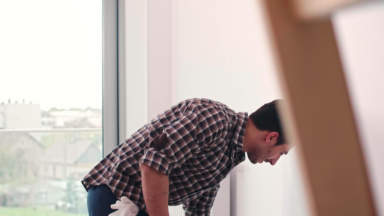 joven pintando la pared interior en un nuevo apartamento