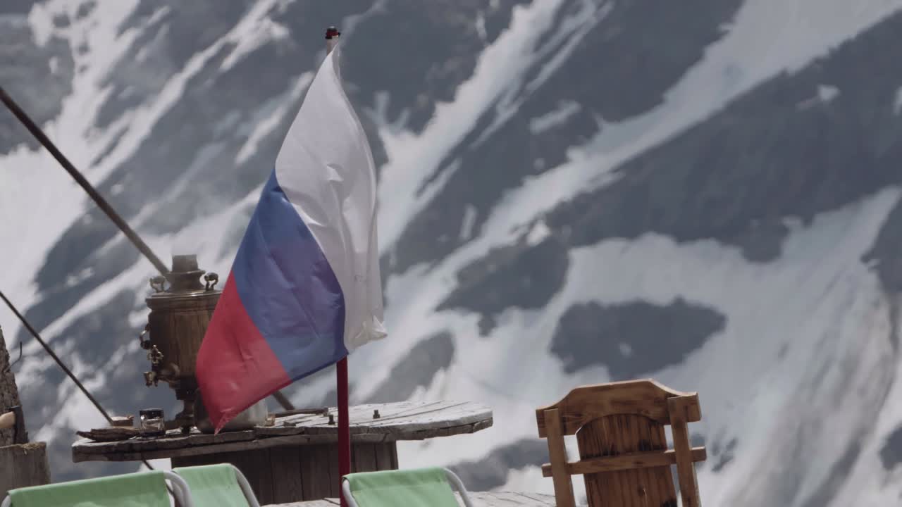 Drapeau russe flottant dans un camping de montagne enneigé