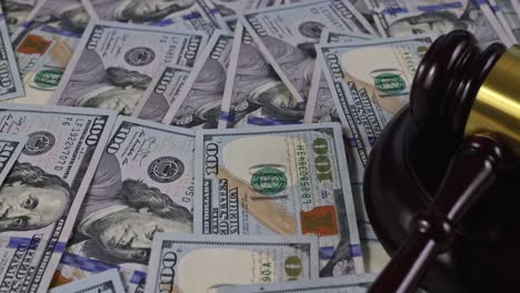 wooden judge gavel with handcuffs on view from one hundred dollar bills in court