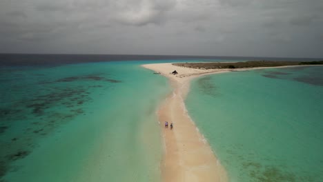 experience the stunning aerial views of cayo de agua beach, where people enjoy the sun and surf. los roques venezuela