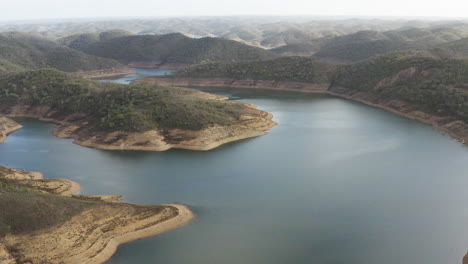 drone-flight-over-the-drainage-basin-with-a-view-on-the-blue-water-and-surrounding-mountains