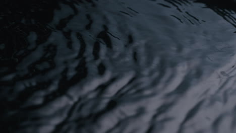 water ripple on black reflected water surface