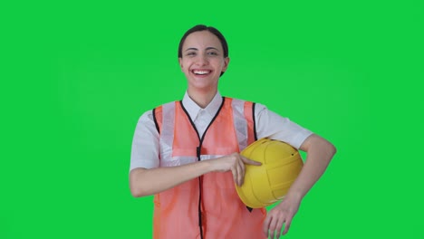 happy indian female architect removing hat after work green screen