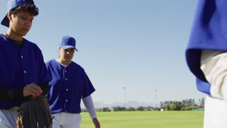 disappointed diverse female baseball players, walking off the field after losing a game