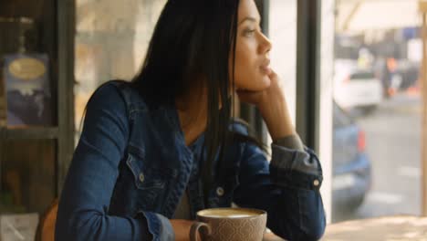 front view of young mixed-race woman looking through window in cafe 4k