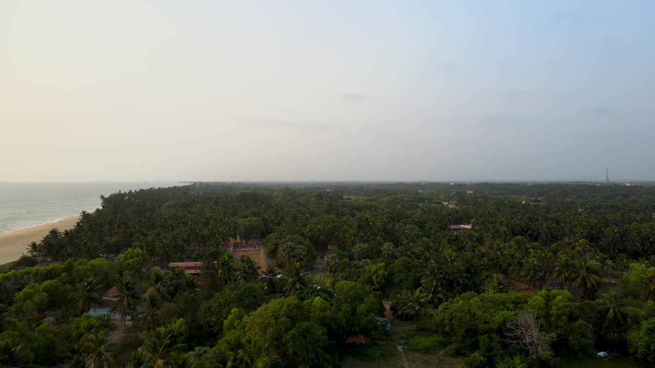 tomada aérea del faro de la playa de kapu en medio del océano y la arena en udupi