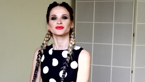 portrait of a beautiful woman in a dress with long pigtails