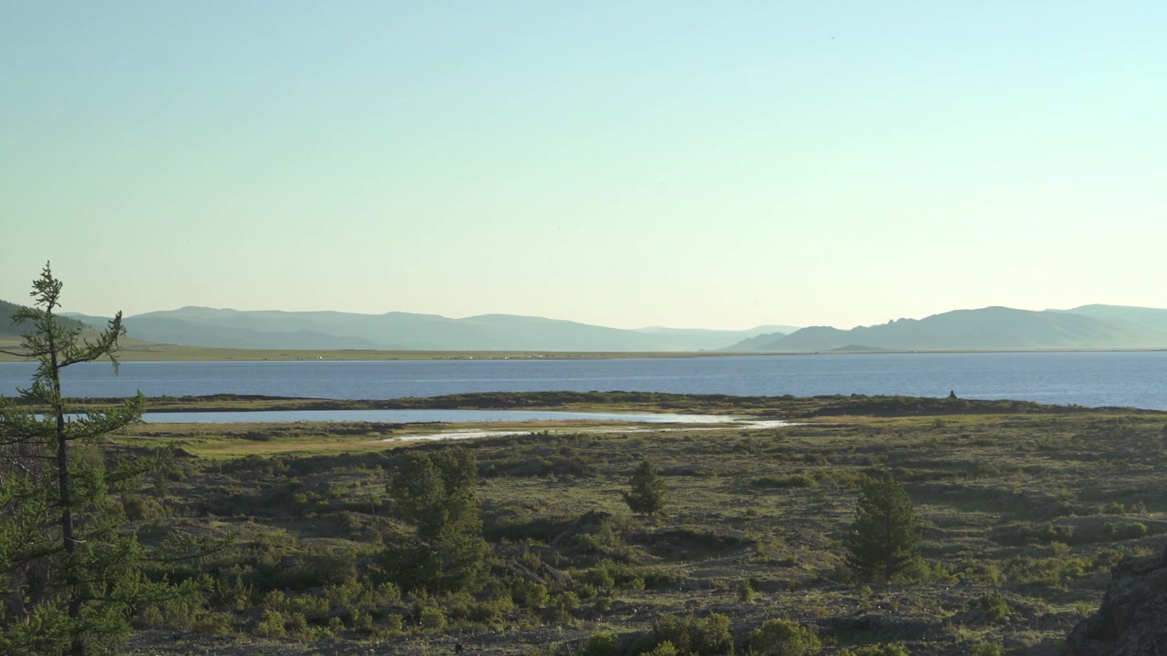 Panoramic View of a Serene Lake Surrounded by Mountains and Rocky Terrain