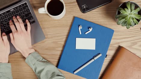 person working at a desk with laptop and other essentials