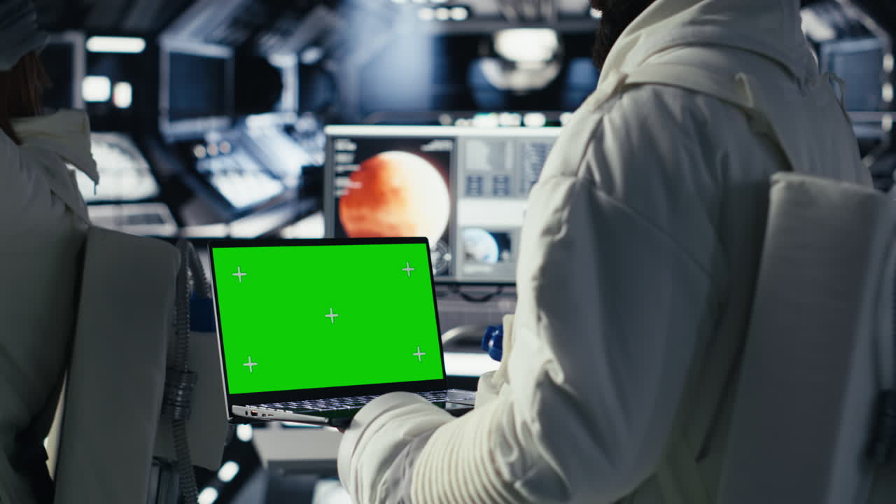 Astronauts reviewing onboard analytics on isolated screen tablet