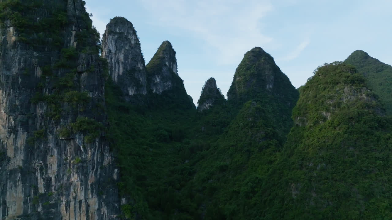 Aerial view flying in middle of karst mountains, sunny evening in Xingping, China