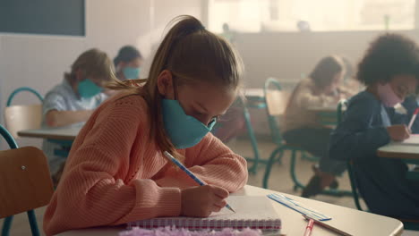 Chica-Inteligente-Con-Máscara-Médica-Escolarizada-En-El-Aula-Durante-La-Pandemia-Del-Coronavirus