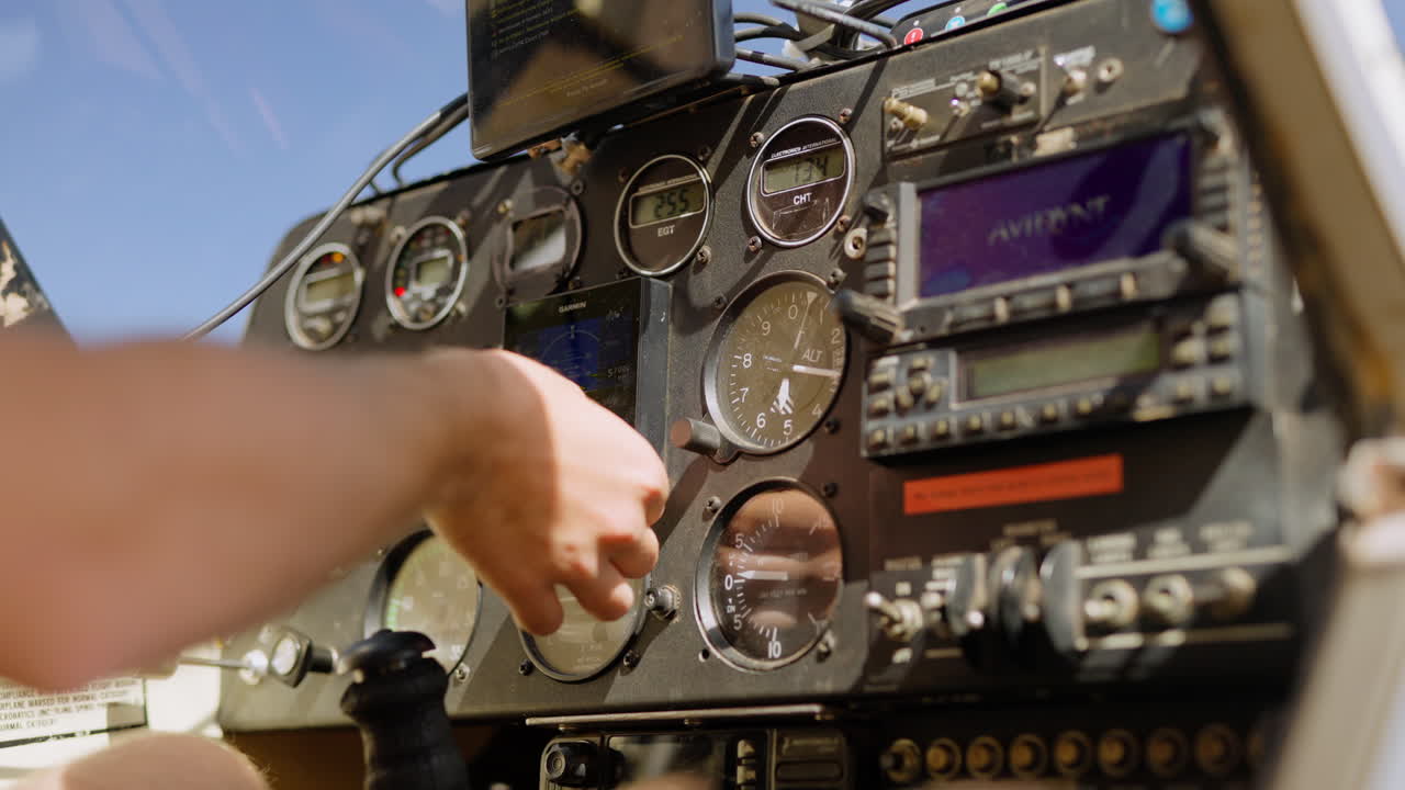 Pilota che regola gli strumenti nella cabina di pilotaggio di un piccolo aereo