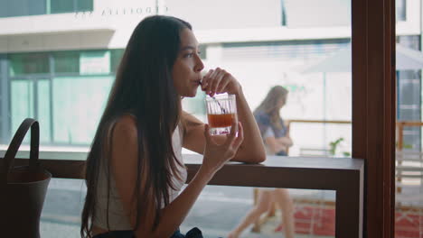 mujer bebiendo en una cafetería