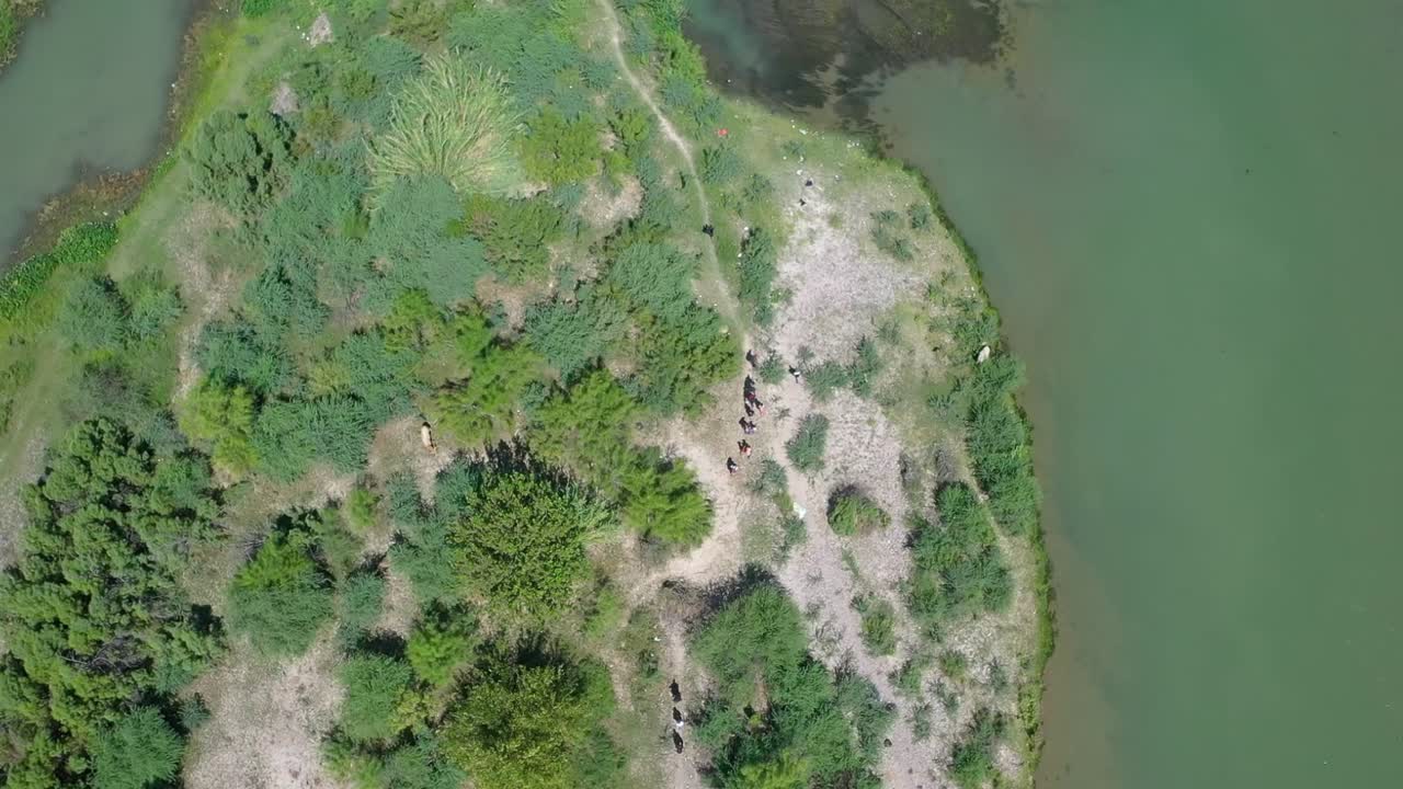 이민자들이 리오 그란데 강을 건너 텍사스 에 있는 이글 패스 (eagle pass) 로 들어간다.